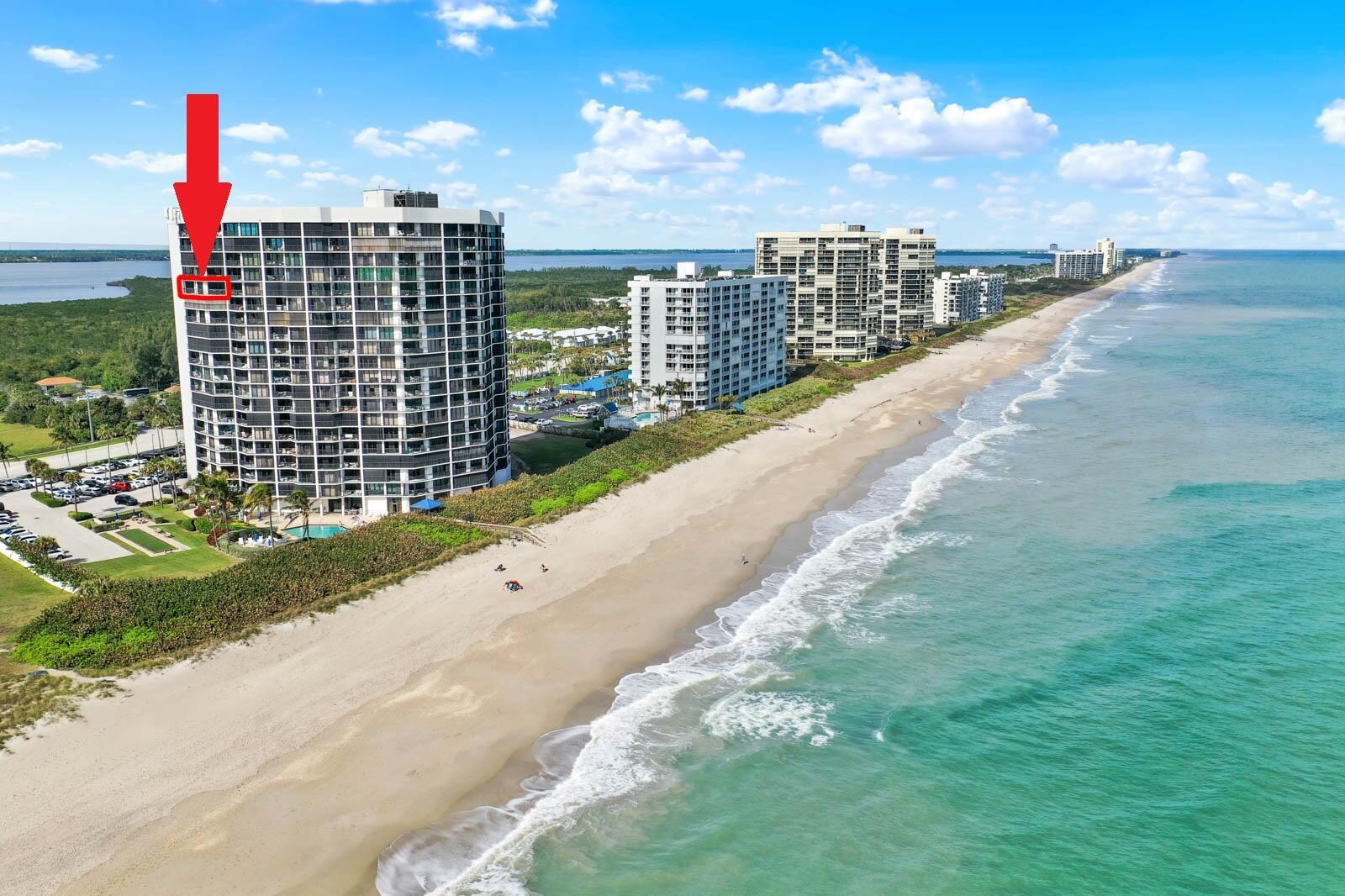 An aerial view of a high-rise beachfront condominium building with a red arrow pointing upward — 9650 S Ocean Drive # 1610, Jensen Beach FL 34957, JENSEN BEACH, FL