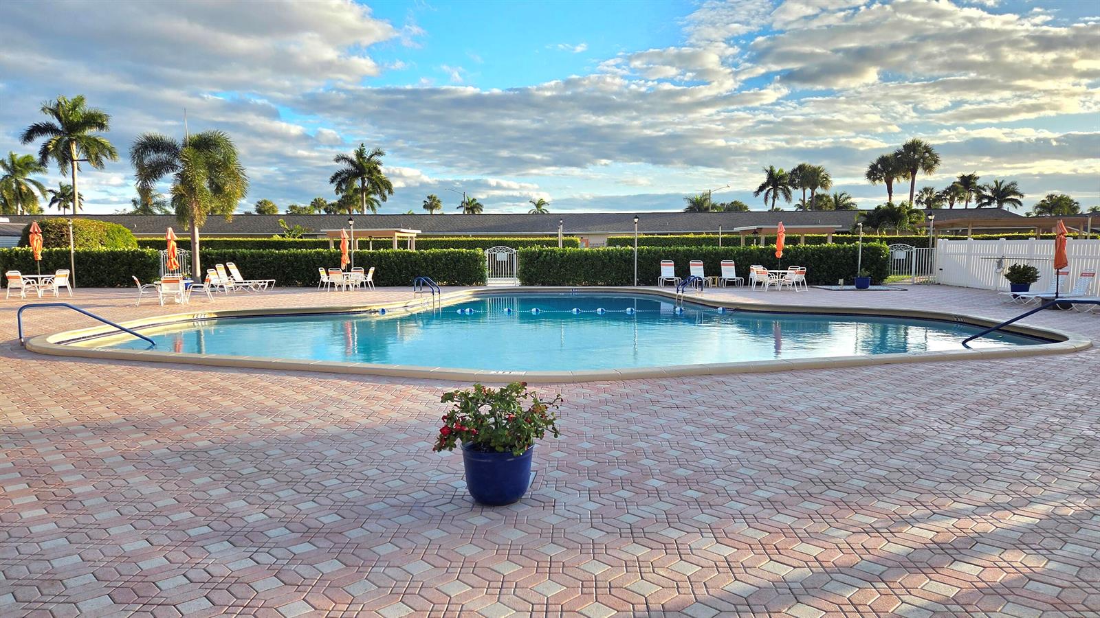 A swimming pool surrounded by a brick paver deck, lounge chairs, and palm trees — 2568 Dudley Drive E # G, West Palm Beach FL 33415, WEST PALM BEACH, FL