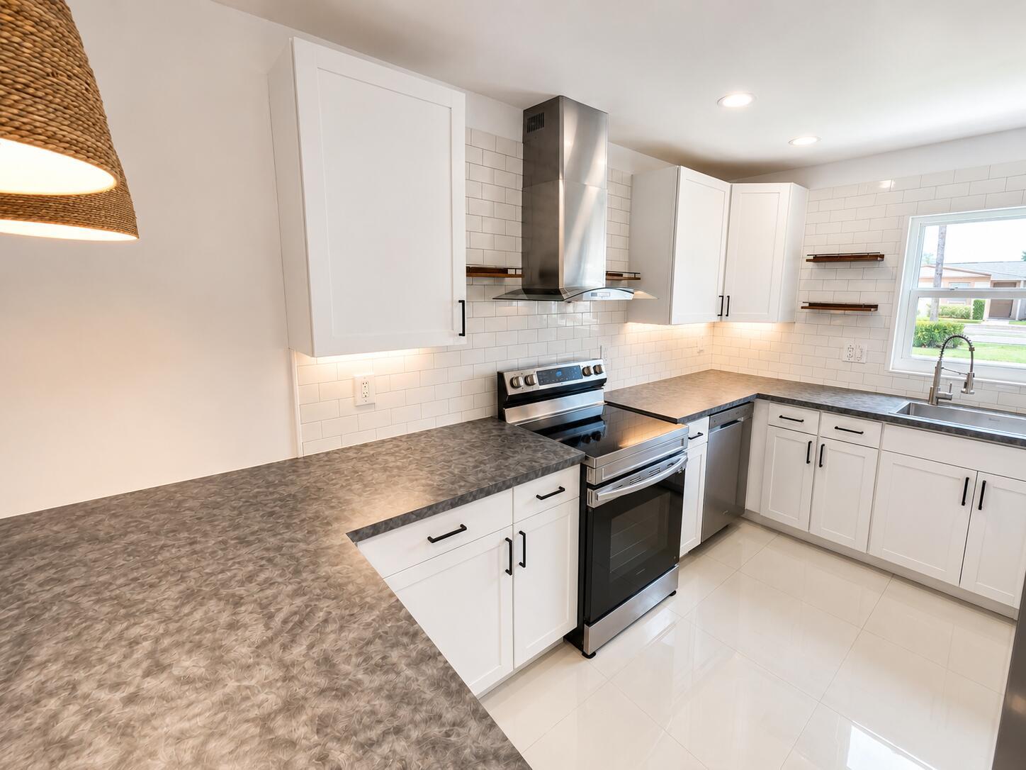 A kitchen with white cabinets, gray countertops, stainless steel appliances, and white subway tile backsplash — 2568 Dudley Drive E # G, West Palm Beach FL 33415, WEST PALM BEACH, FL
