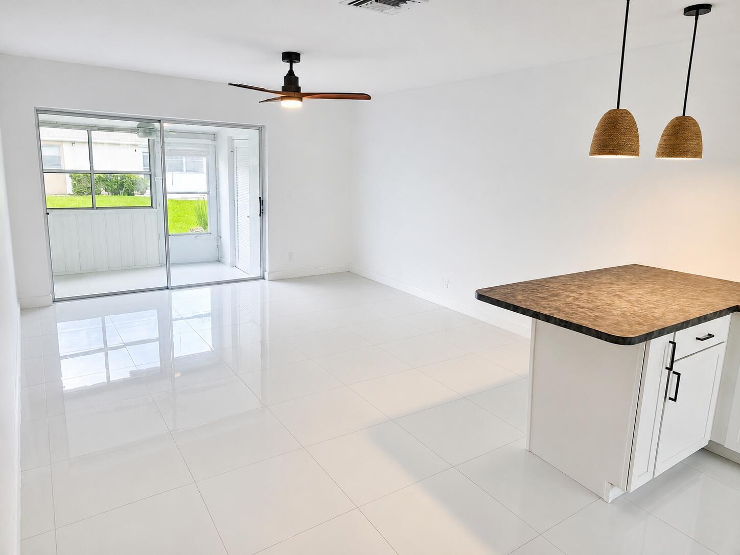 A bright room with white tile floors, a ceiling fan, and a kitchen island — 2568 Dudley Drive E # G, West Palm Beach FL 33415, WEST PALM BEACH, FL