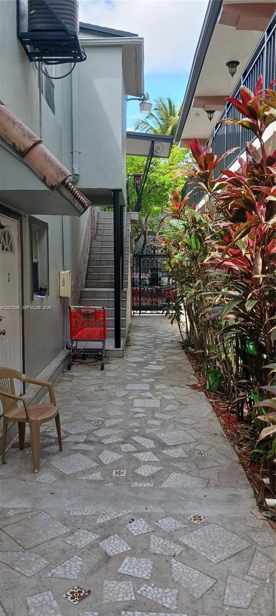 A paved walkway leads between two buildings toward a metal gate with stairs nearby — 2272 SW 8th St # 3, Miami FL 33135, MIAMI, FL