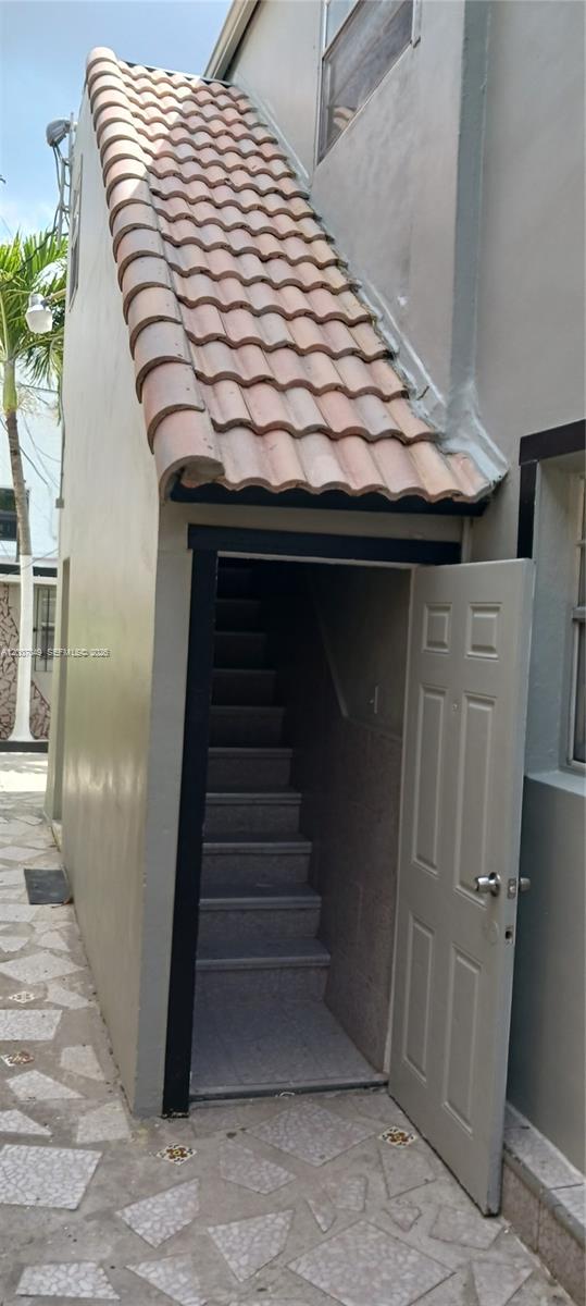 An exterior view shows a doorway leading to an indoor staircase beneath a tiled roof — 2272 SW 8th St # 3, Miami FL 33135, MIAMI, FL