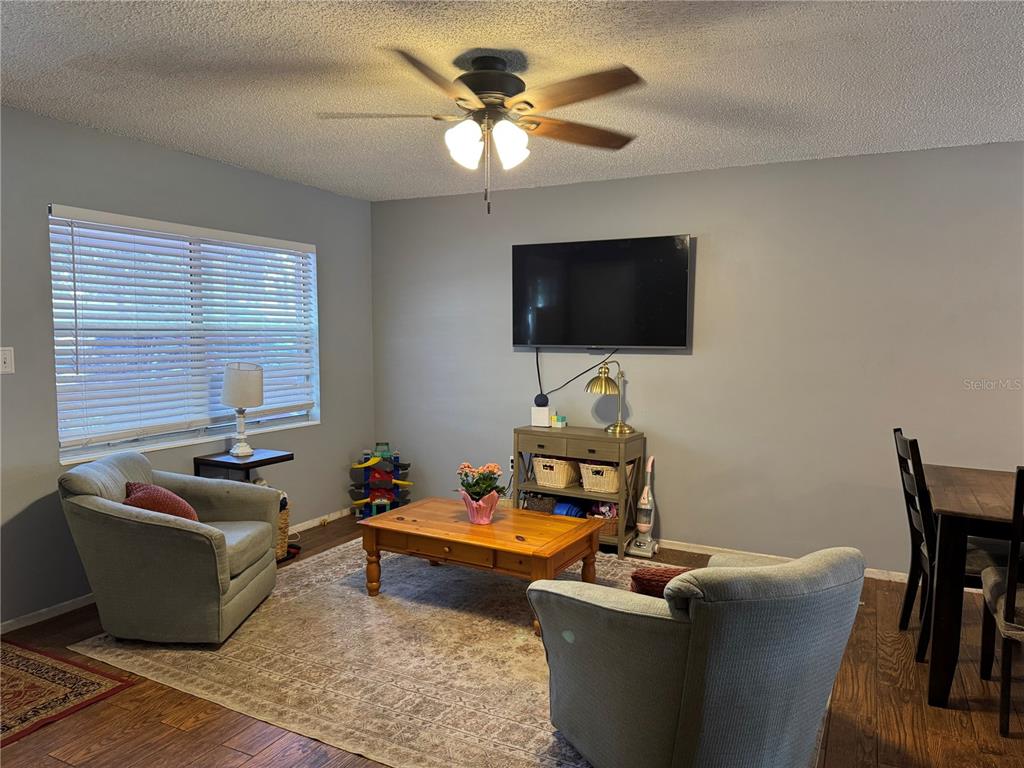 A living room features two armchairs, a wooden coffee table, and a wall-mounted television — 580 FERN AVENUE, TAVARES, FL