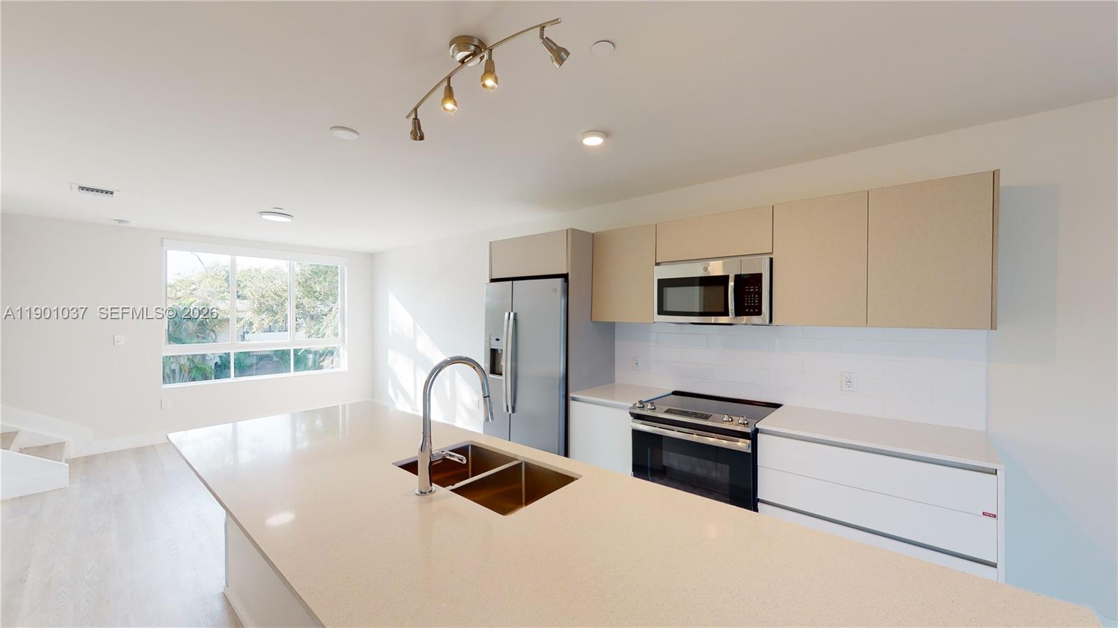 A modern kitchen features a large island, stainless steel appliances, and light-colored cabinetry — 2555 NE 193rd St # 2224, Miami FL 33180, MIAMI, FL