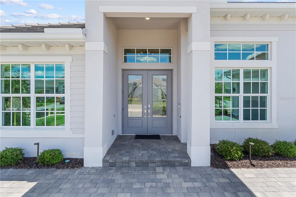The exterior of a house features a gray double front door under a covered entryway — 15860 CRANES MARSH COURT, PUNTA GORDA, FL