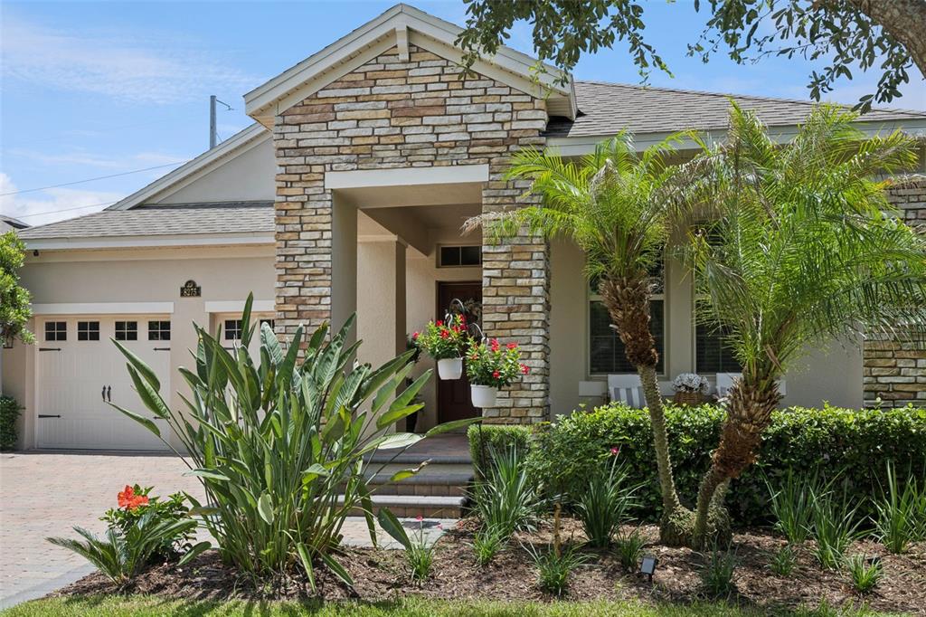 A single-story house with a stone-accented entryway, a two-car garage, and a landscaped front yard — 8275 BAYVIEW CROSSING DRIVE, WINTER GARDEN, FL