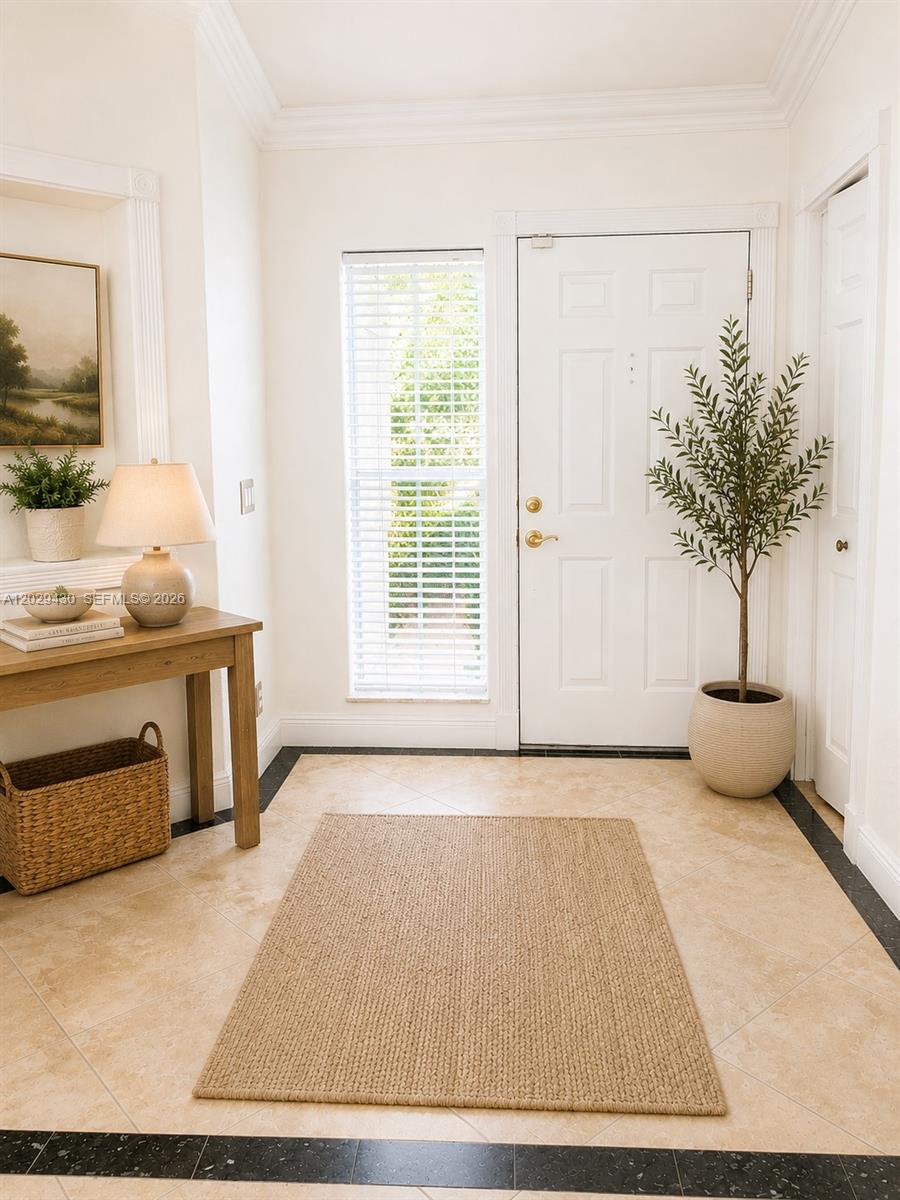 A bright entryway features a console table, a potted plant, and a neutral area rug — 569 Spinnaker, Weston FL 33326, WESTON, FL