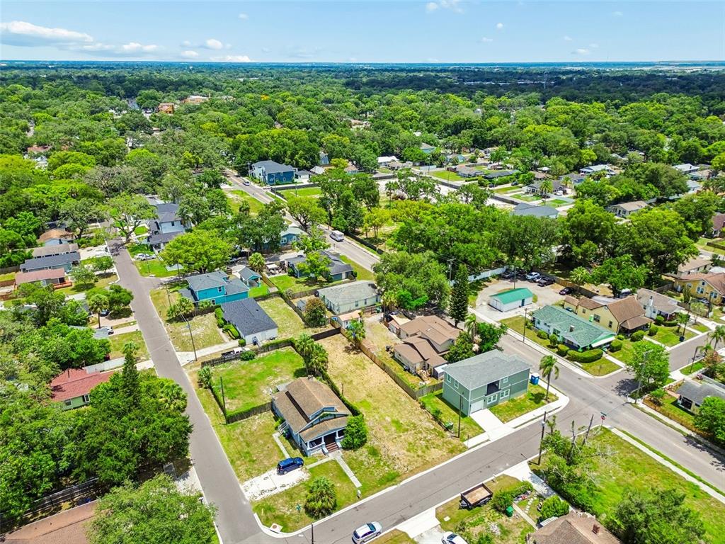 An aerial view shows a residential neighborhood with houses, streets, and many green trees — 4805 N 10TH STREET, TAMPA, FL