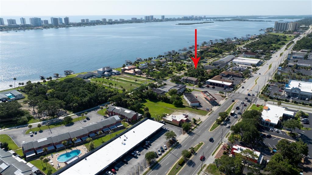 An aerial view shows a coastal area with buildings, a road, and a red arrow — PALMETTO AVENUE, SOUTH DAYTONA, FL