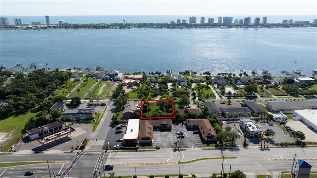 An aerial view shows a vacant lot outlined in red near a waterfront area — PALMETTO AVENUE, SOUTH DAYTONA, FL