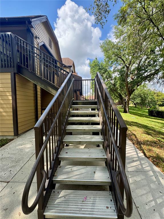 An exterior view shows a metal staircase leading to the second floor of a building — 385 WOODSIDE DRIVE UNIT 201, ALTAMONTE SPRINGS, FL
