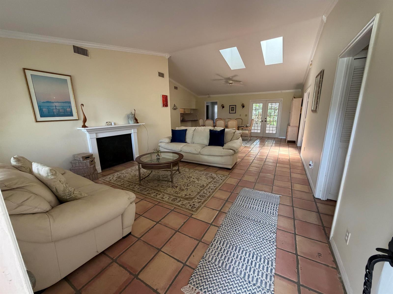 A living room features a fireplace, two sofas, tile flooring, and skylights in the ceiling — 1290 5th Place, Vero Beach FL 32962, VERO BEACH, FL