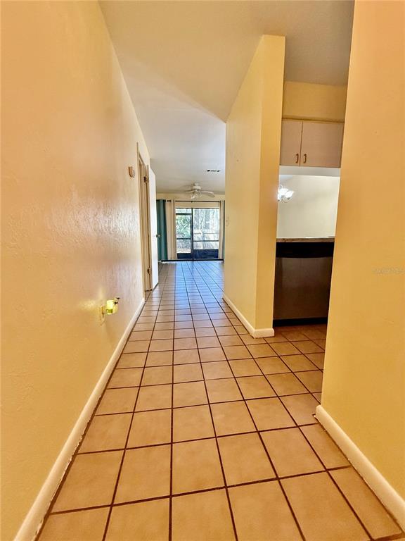 A tiled hallway leads toward a kitchen and a glass sliding door to the outside — 2735 SW 35TH PLACE UNIT 1604, GAINESVILLE, FL