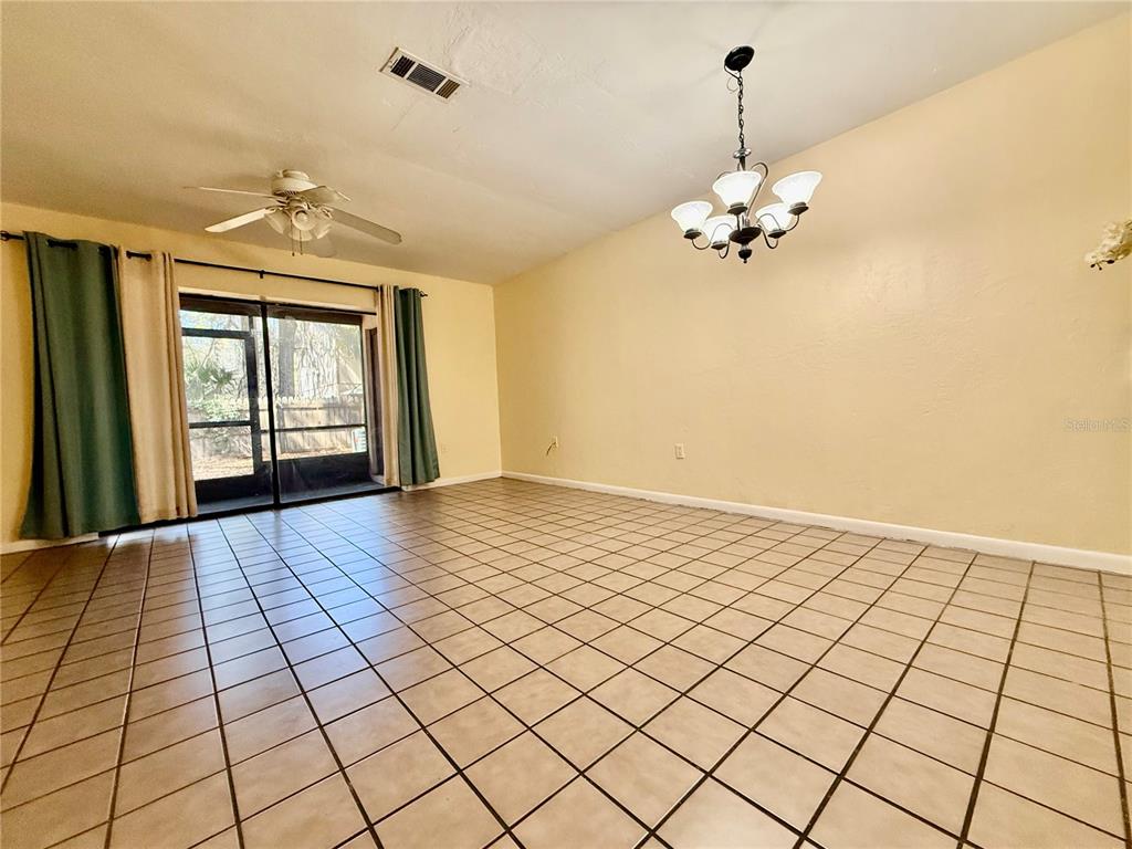 A dining room with beige walls, tile flooring, a ceiling fan, and sliding glass doors — 2735 SW 35TH PLACE UNIT 1604, GAINESVILLE, FL