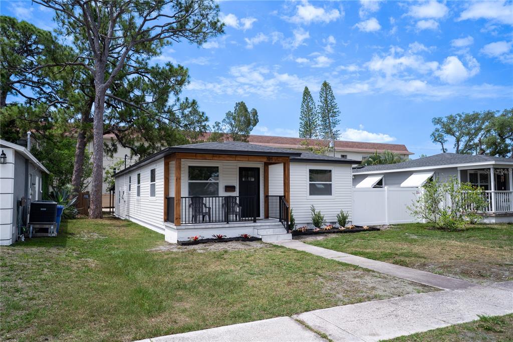 A white single-story house features a front porch with wood-trimmed columns and black railings — 326 41ST AVENUE N, ST PETERSBURG, FL