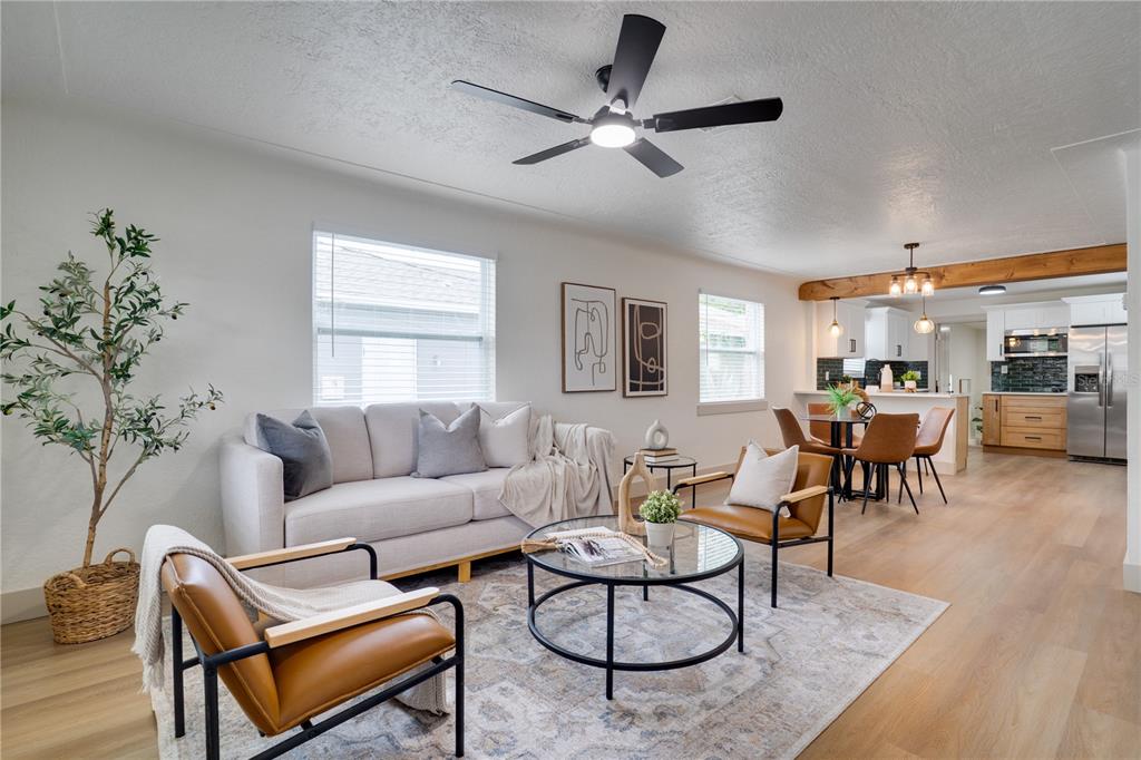 A living room with a sofa, two leather chairs, and an open kitchen in back — 326 41ST AVENUE N, ST PETERSBURG, FL