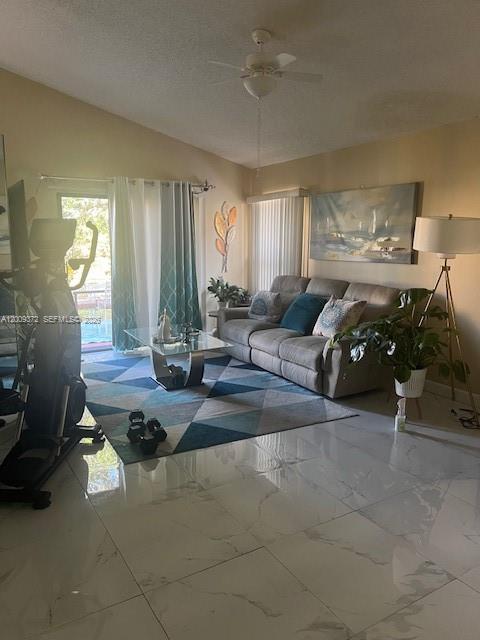 A living room features a grey sofa, a geometric rug, tile floors, and a ceiling fan — 150 Colly Way, North Lauderdale FL 33068, NORTH LAUDERDALE, FL