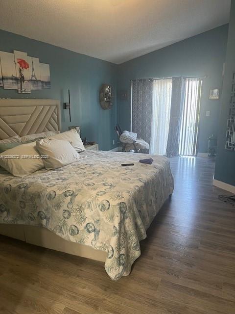 A bedroom features a large bed with a patterned quilt, blue walls, and sliding glass doors — 150 Colly Way, North Lauderdale FL 33068, NORTH LAUDERDALE, FL