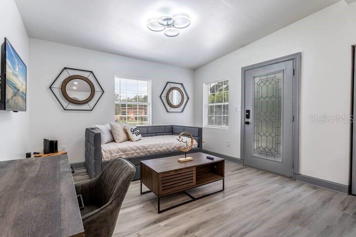 A room with a daybed, coffee table, desk, and gray door with a glass insert — 511 SAN JUAN BOULEVARD, ORLANDO, FL