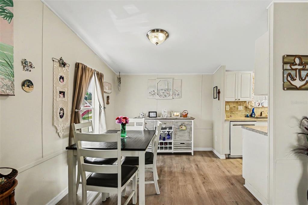 A dining area features a dark wood table, white chairs, and light wood-look flooring — 1000 KINGS HIGHWAY UNIT 366, PUNTA GORDA, FL