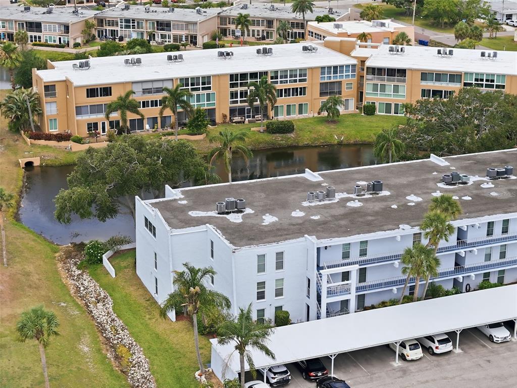 An aerial view shows two multi-story apartment buildings separated by a small pond — 225 COUNTRY CLUB DRIVE UNIT C332, LARGO, FL