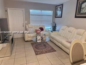 A living room features white leather sofas, a glass coffee table, and light-colored tile floors — 4620 SW 31st Dr, West Park FL 33023, WEST PARK, FL