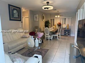 A living room with a white leather sofa and a dining area with a table — 4620 SW 31st Dr, West Park FL 33023, WEST PARK, FL