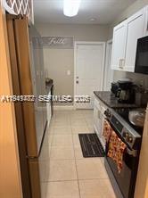 A kitchen features stainless steel appliances, white cabinets, and light-colored tile flooring — 4620 SW 31st Dr, West Park FL 33023, WEST PARK, FL