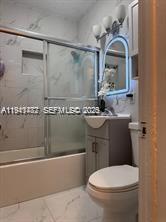 A bathroom features a walk-in shower with marble-look tile, a vanity, and a toilet — 4620 SW 31st Dr, West Park FL 33023, WEST PARK, FL