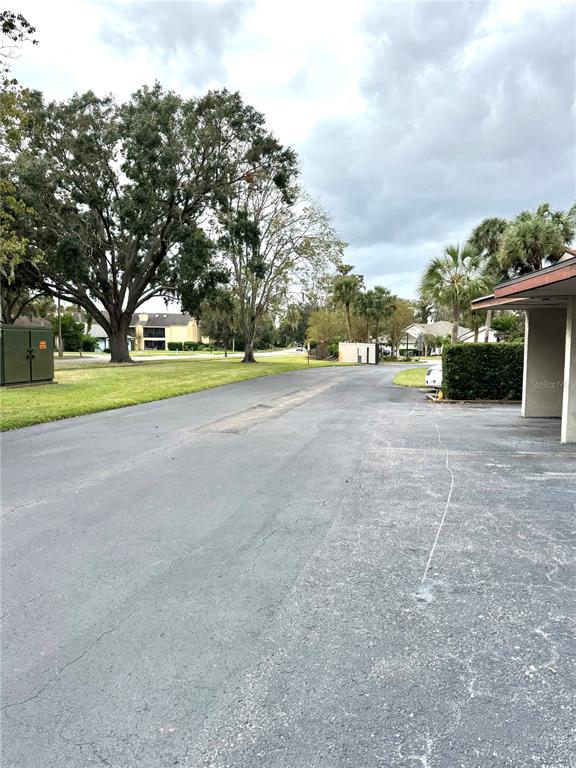 An asphalt parking lot sits in front of a large tree and apartment buildings — 4229 S LAKE ORLANDO PARKWAY UNIT 133, ORLANDO, FL