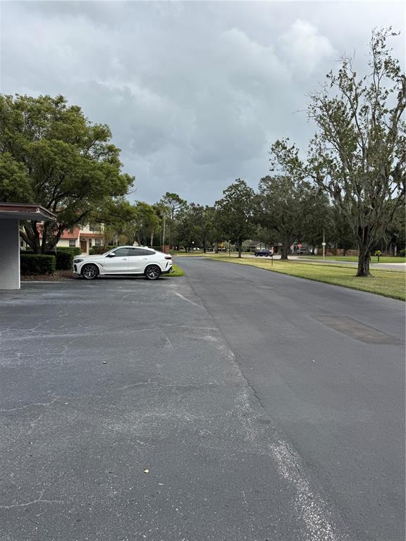 A white SUV is parked in a paved lot next to trees and a building — 4229 S LAKE ORLANDO PARKWAY UNIT 133, ORLANDO, FL