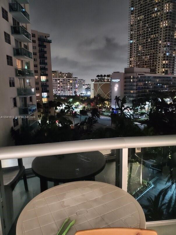 A balcony view at night overlooking city buildings and palm trees — 3901 S Ocean Dr # 8T, Hollywood FL 33019, HOLLYWOOD, FL