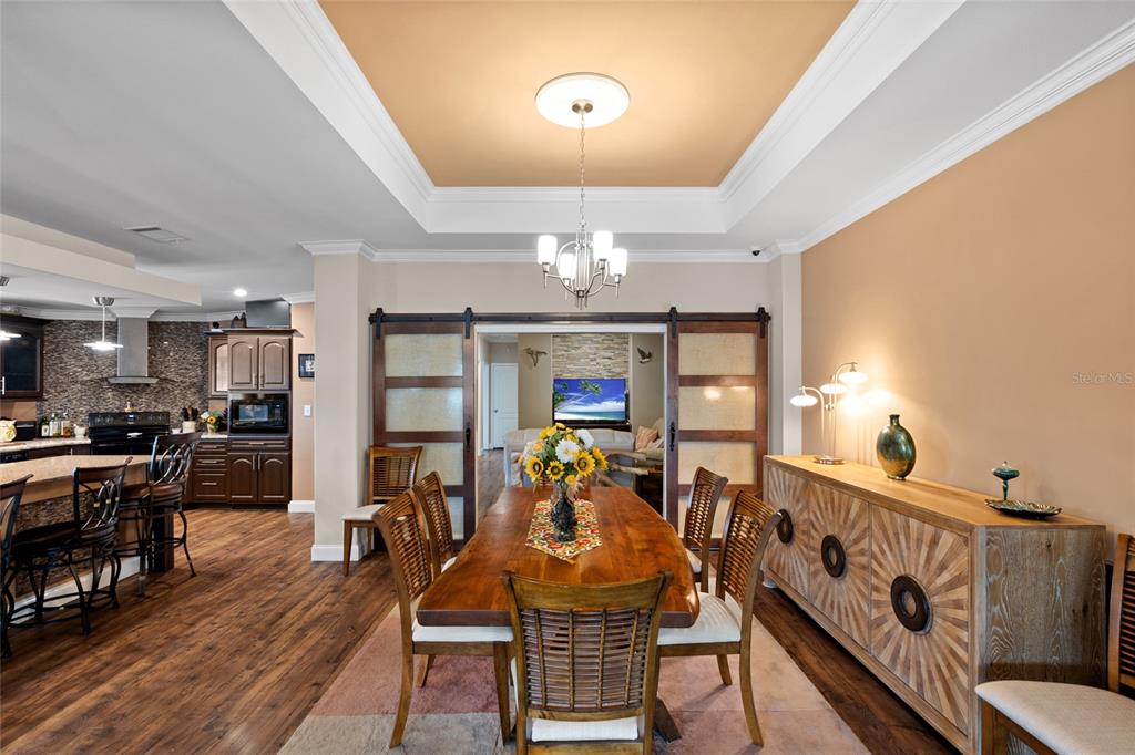 A dining room features a wooden table, sliding barn doors, and a tray ceiling — 2715 9TH AVENUE N, ST PETERSBURG, FL