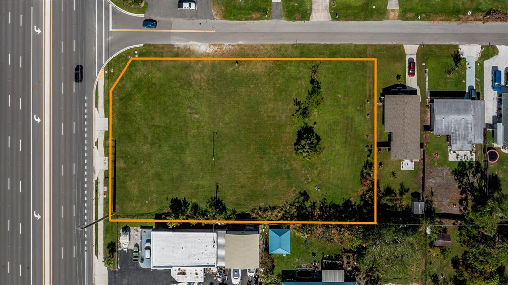 An aerial view shows a vacant rectangular lot bordered by a road and adjacent properties — 601 US HIGHWAY 41 BYPASS S, VENICE, FL