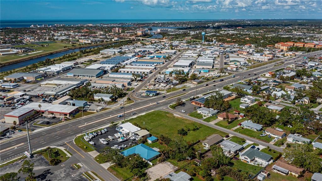 An aerial view shows a commercial area with warehouses, a main road, and nearby residential homes — 601 US HIGHWAY 41 BYPASS S, VENICE, FL