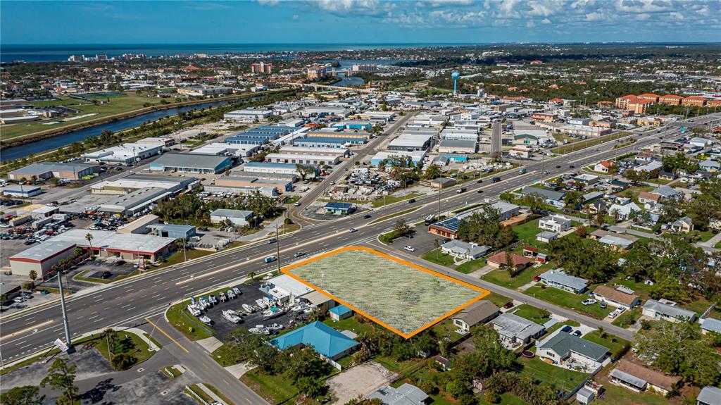 An aerial view shows a vacant rectangular lot outlined in orange near a busy road — 601 US HIGHWAY 41 BYPASS S, VENICE, FL