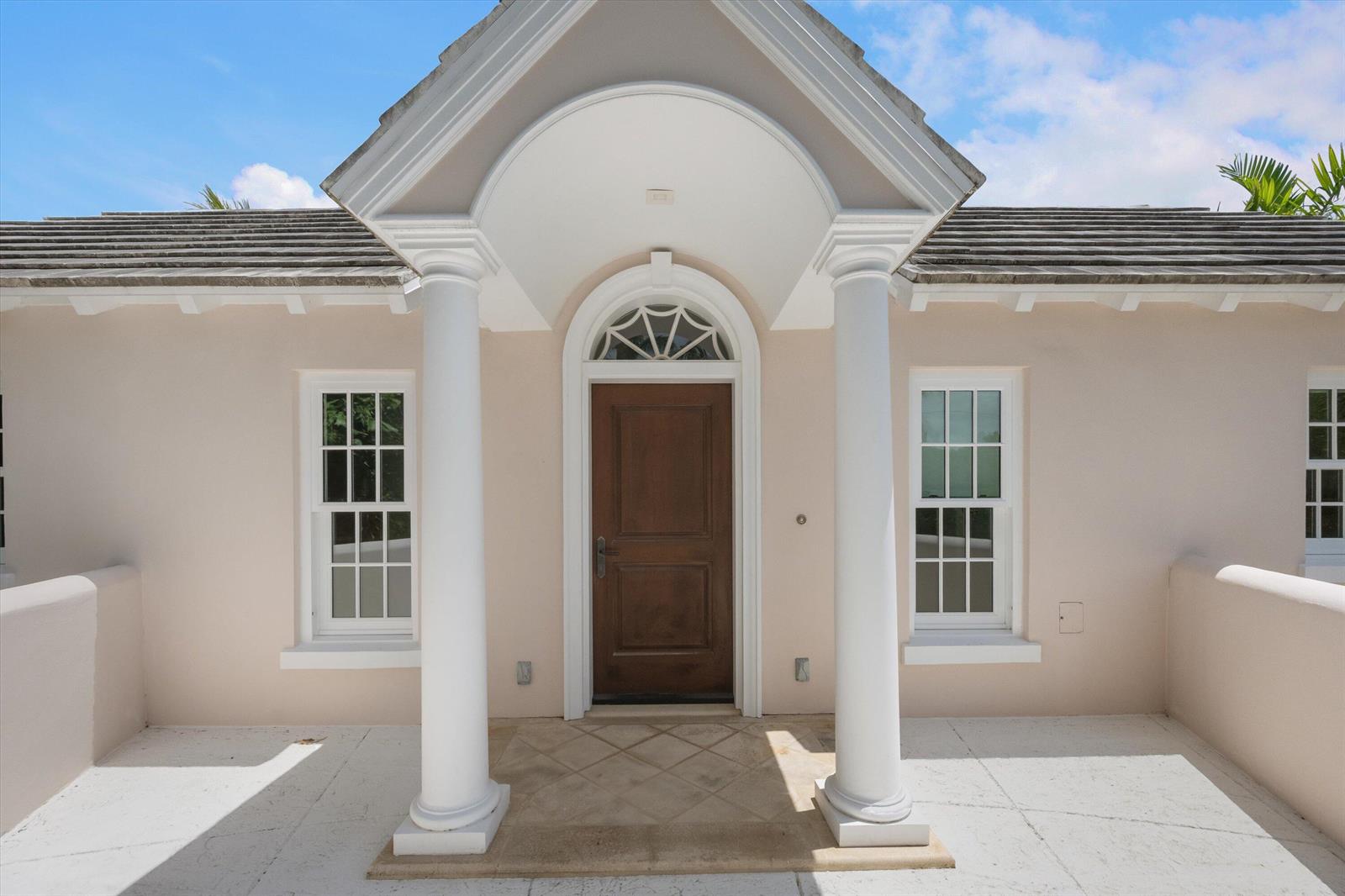 A front entrance with a wooden door, arched transom, and two white columns under a portico — 750 S County Road, Palm Beach FL 33480, PALM BEACH, FL