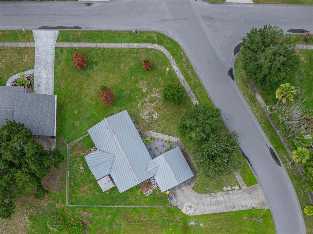 An aerial view shows a house with a metal roof, driveway, and fenced backyard — 3623 OPAL DRIVE, MULBERRY, FL