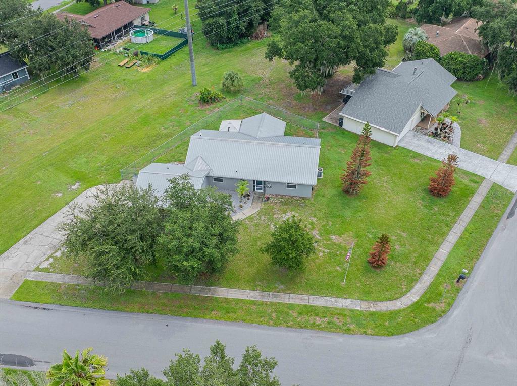 An aerial view shows a gray house with a metal roof on a corner lot — 3623 OPAL DRIVE, MULBERRY, FL