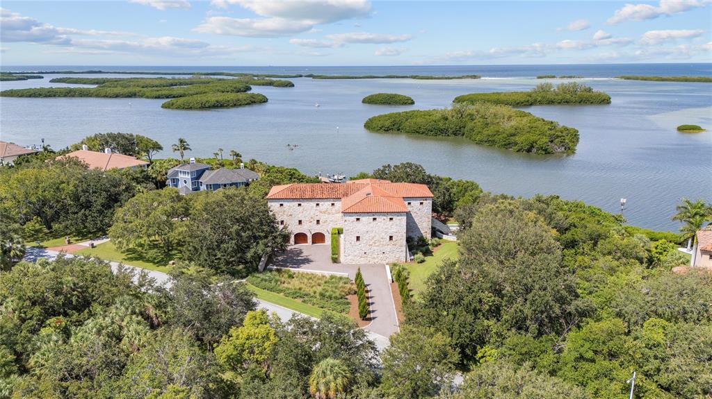 An aerial view shows a stone house with a red tile roof near water — 1571 OCEANVIEW DRIVE, ST PETERSBURG, FL