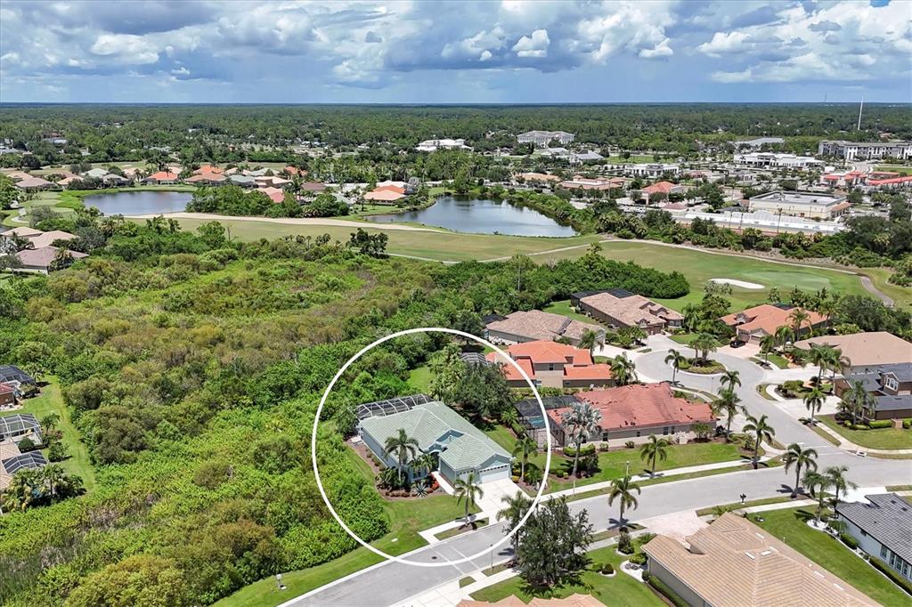 An aerial view shows a single-story house with a screened pool enclosure in a neighborhood — 5158 GRAND PALMETTO WAY, NORTH PORT, FL