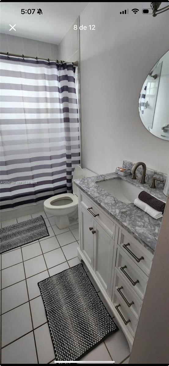 A bathroom features a white vanity with a marble countertop, a toilet, and a shower curtain — 9309 SW 166th Ct, Miami FL 33196, MIAMI, FL