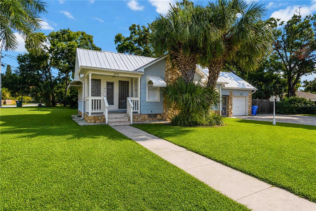 A light blue house with a metal roof, stone accents, and a front porch — 2016 VIRGINIA DRIVE, BRADENTON, FL