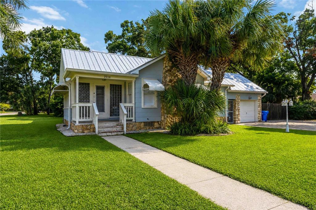 A single-story house with a metal roof, stone accents, and a front porch — 2016 VIRGINIA DRIVE, BRADENTON, FL