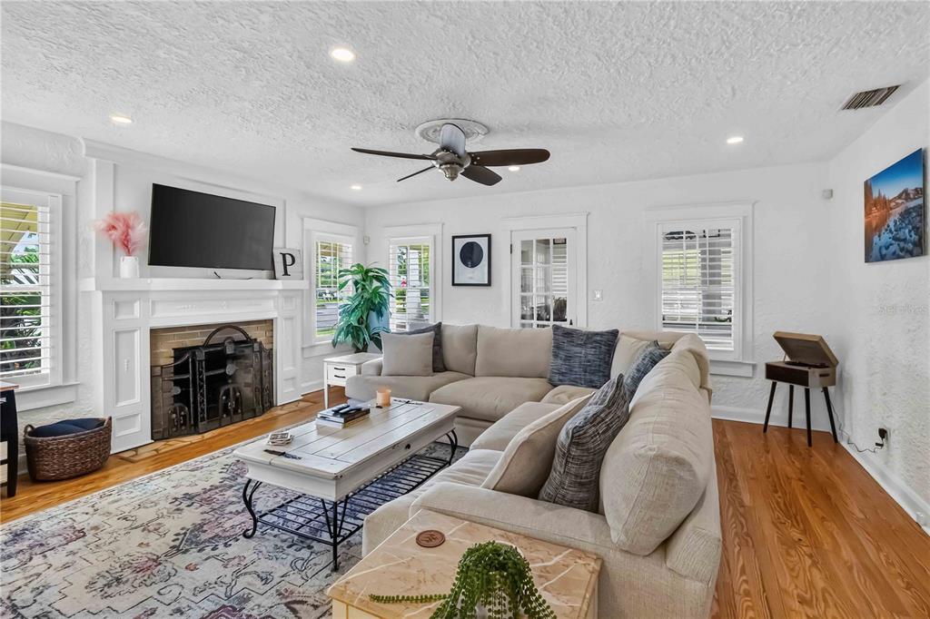 A living room features a fireplace, a large sectional sofa, and hardwood floors — 2016 VIRGINIA DRIVE, BRADENTON, FL