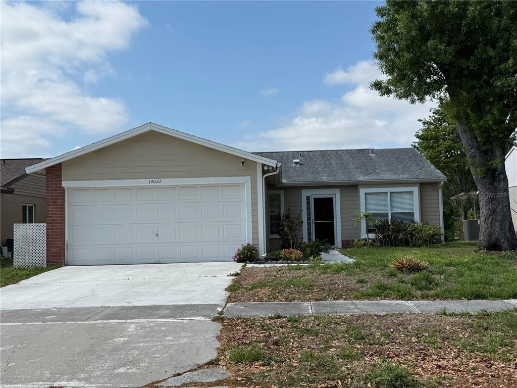 A single-story house with a beige exterior, a two-car garage, and a large tree — 14022 CITRUS POINTE DRIVE, TAMPA, FL
