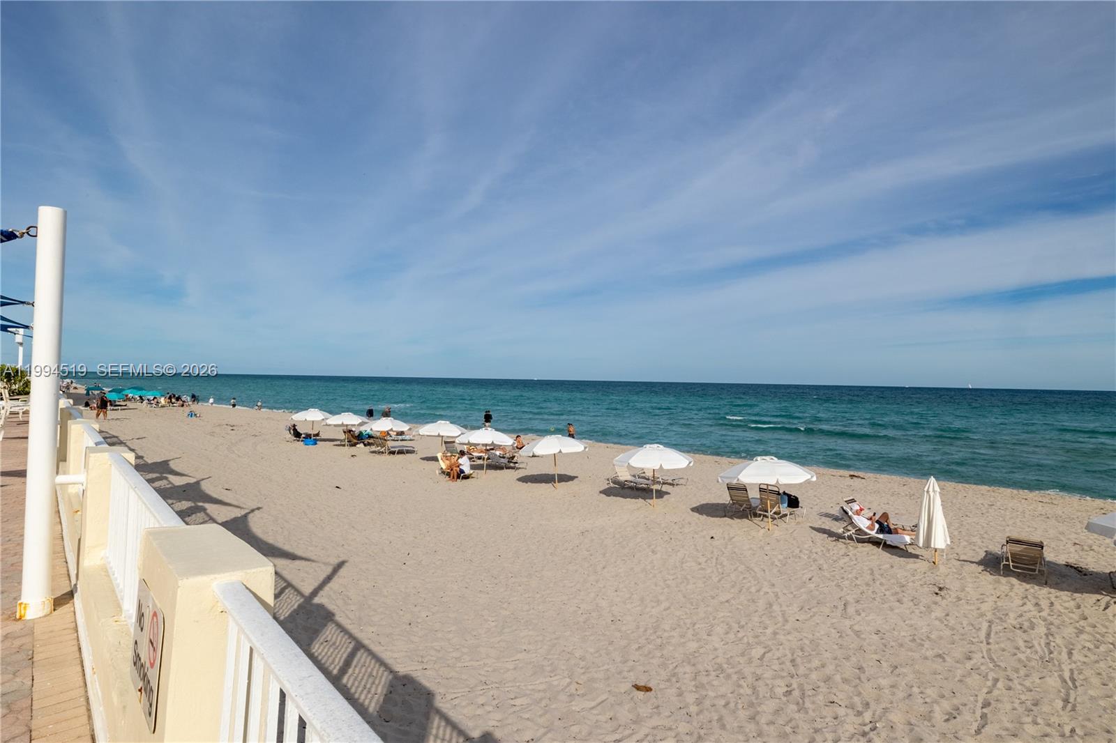 A large, curved high-rise apartment building overlooks a pool deck with lounge chairs and umbrellas — 3180 S Ocean Dr # 718, Hallandale Beach FL 33009, HALLANDALE BEACH, FL