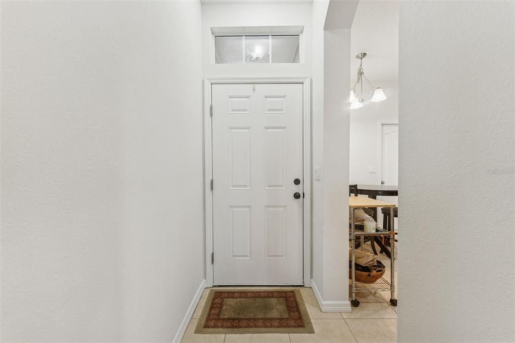 A white front door with a transom window opens into a tiled entryway — 2129 LENNOX DALE LANE, BRANDON, FL