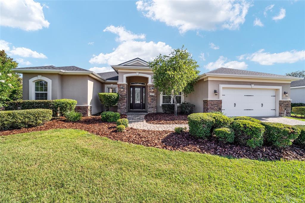 A single-story suburban house with a stone-accented entryway, a two-car garage, and landscaped front yard — 4417 SW 65TH PLACE, OCALA, FL