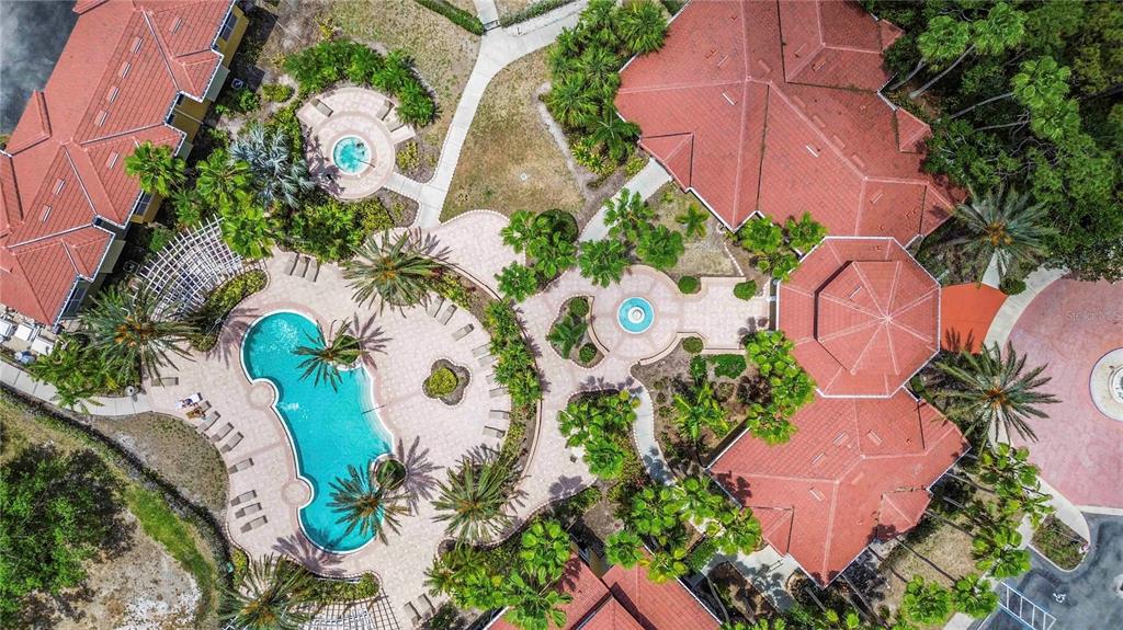 An aerial view shows a community swimming pool, hot tub, and clubhouse with red roofs — 5721 BENTGRASS DRIVE UNIT 20-104, SARASOTA, FL